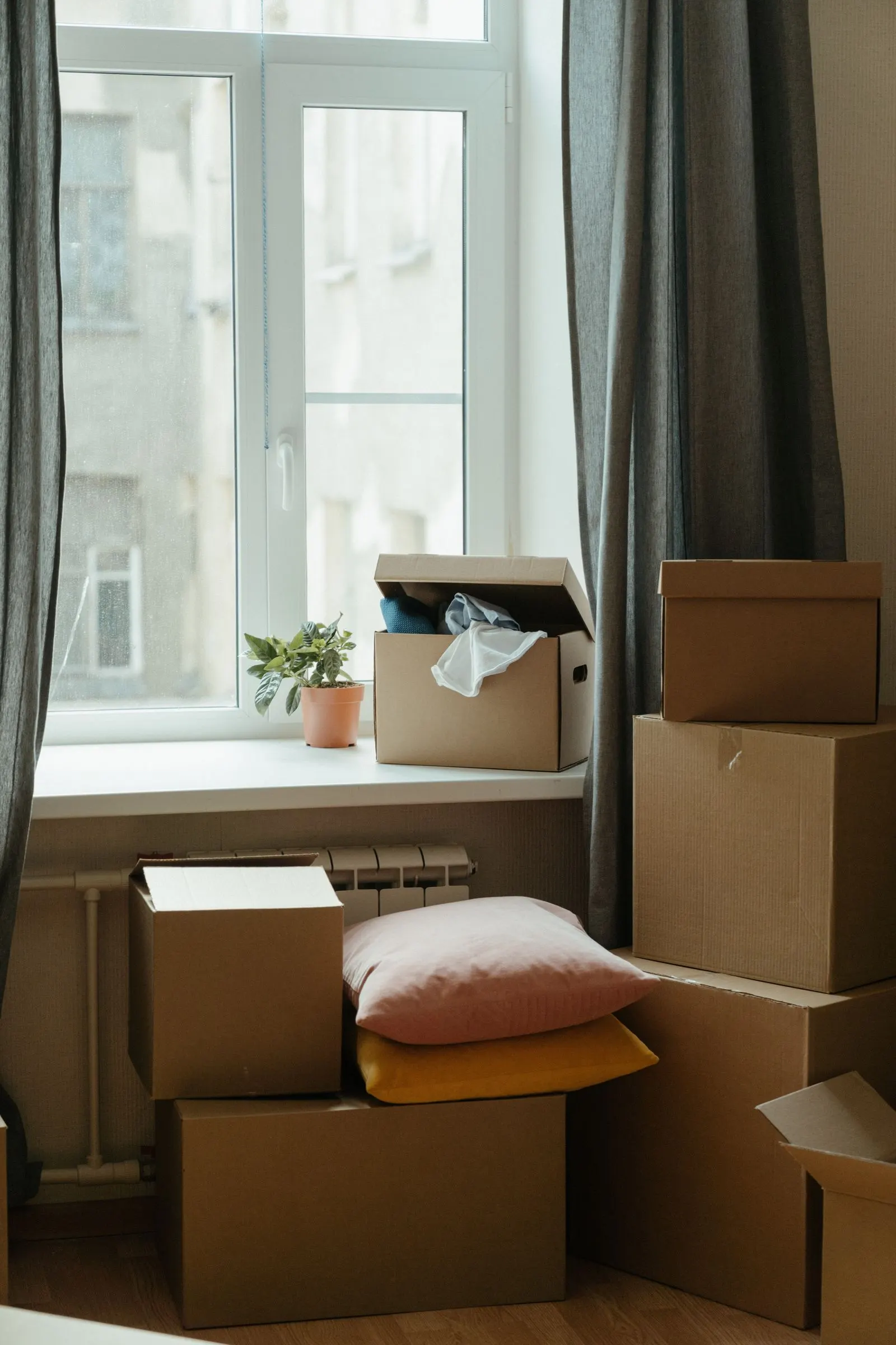 Stacked moving boxes in a bright room, ready for relocation